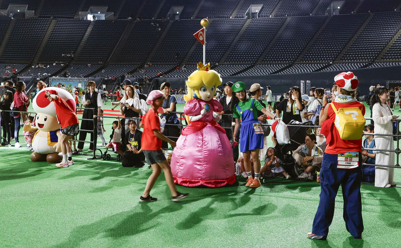 ゴールで「スーパーマリオ」のキャラクターに出迎えられる参加者＝13日午前、札幌市(共同)