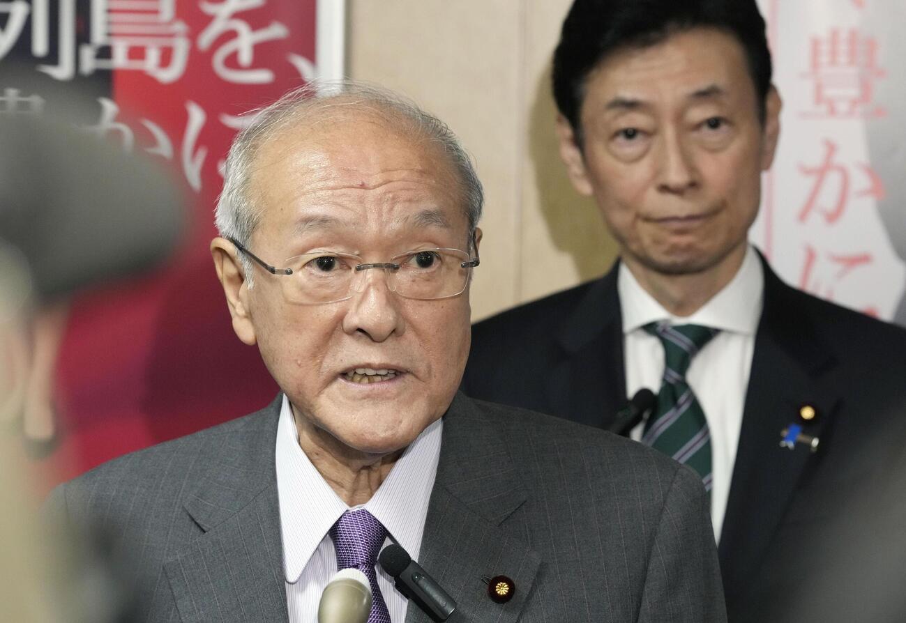 沖縄県知事選で古謝玄太氏の当選が決まり、記者団の取材に応じる自民党の鈴木幹事長。奥は西村選対委員長＝13日夜、東京・永田町の党本部(共同)