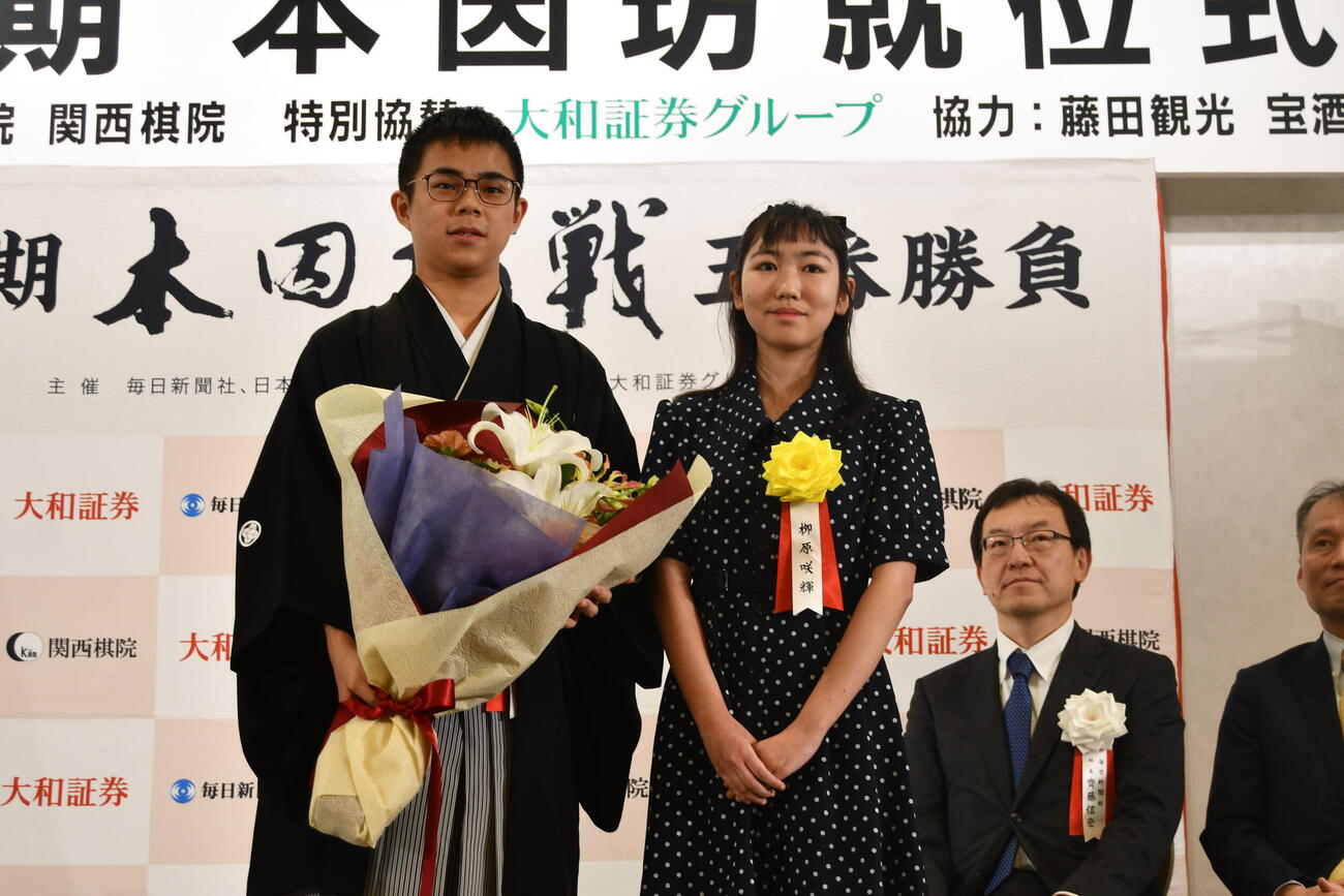 福岡航太朗本因坊（左）は後輩の柳原咲輝二段（右）から花束を贈られる