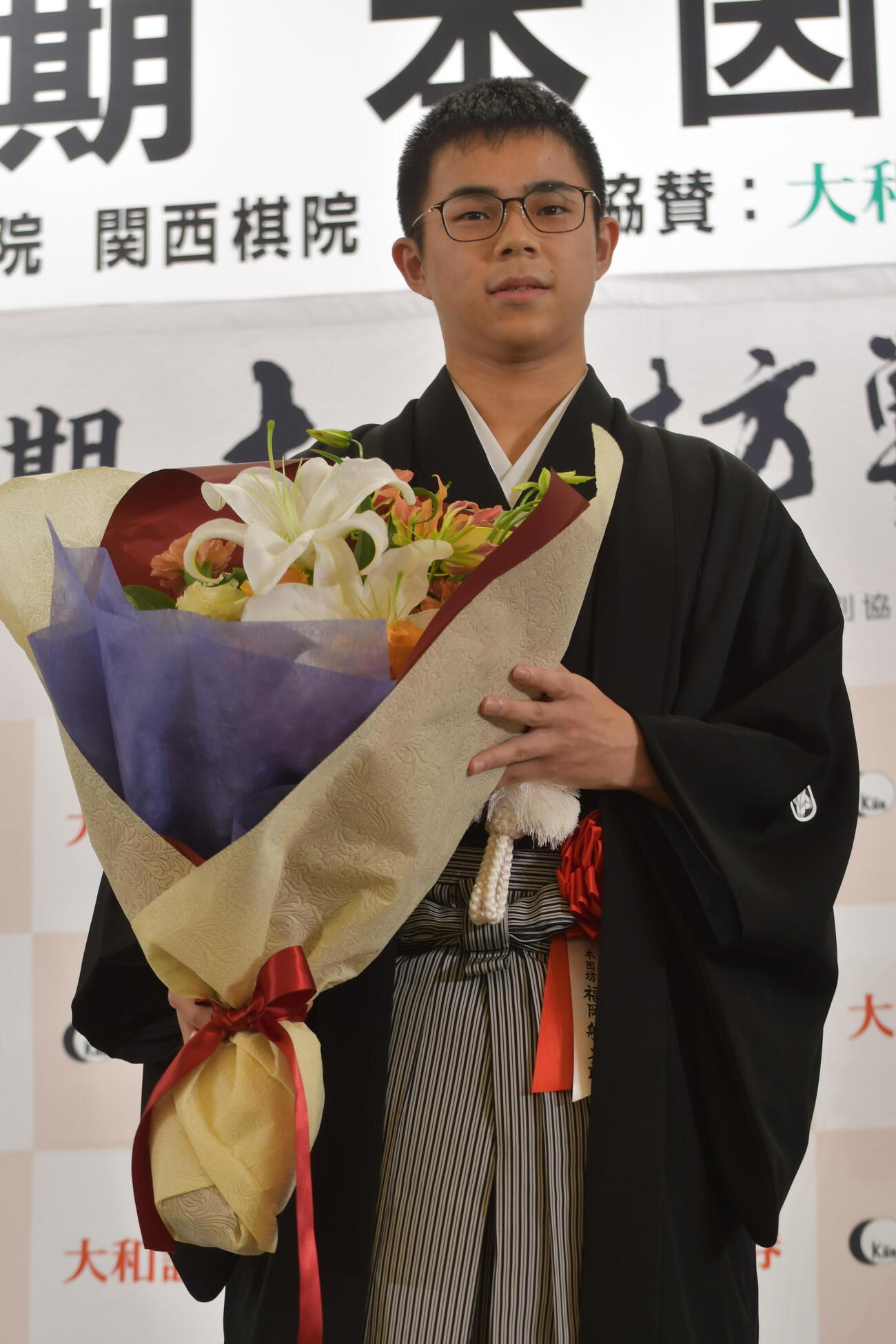 花束を手にする福岡航太朗本因坊