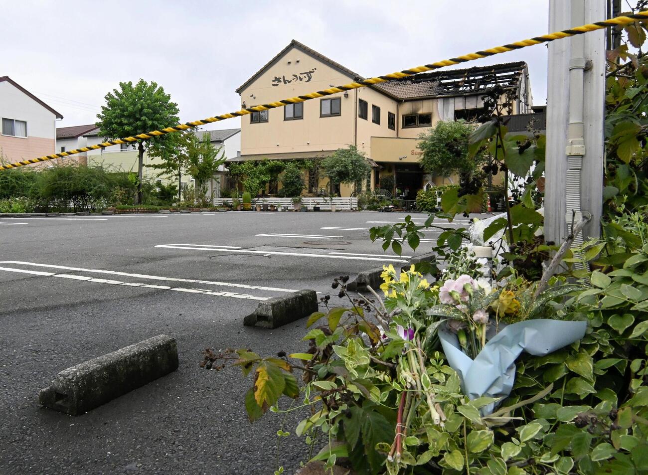 花束が手向けられた事件現場のケーキ店＝11日午後、岐阜県本巣市(共同)