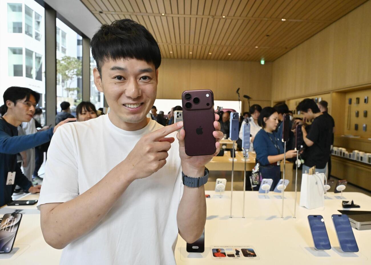 購入した「iPhone18プロ」を手にする男性（共同）
