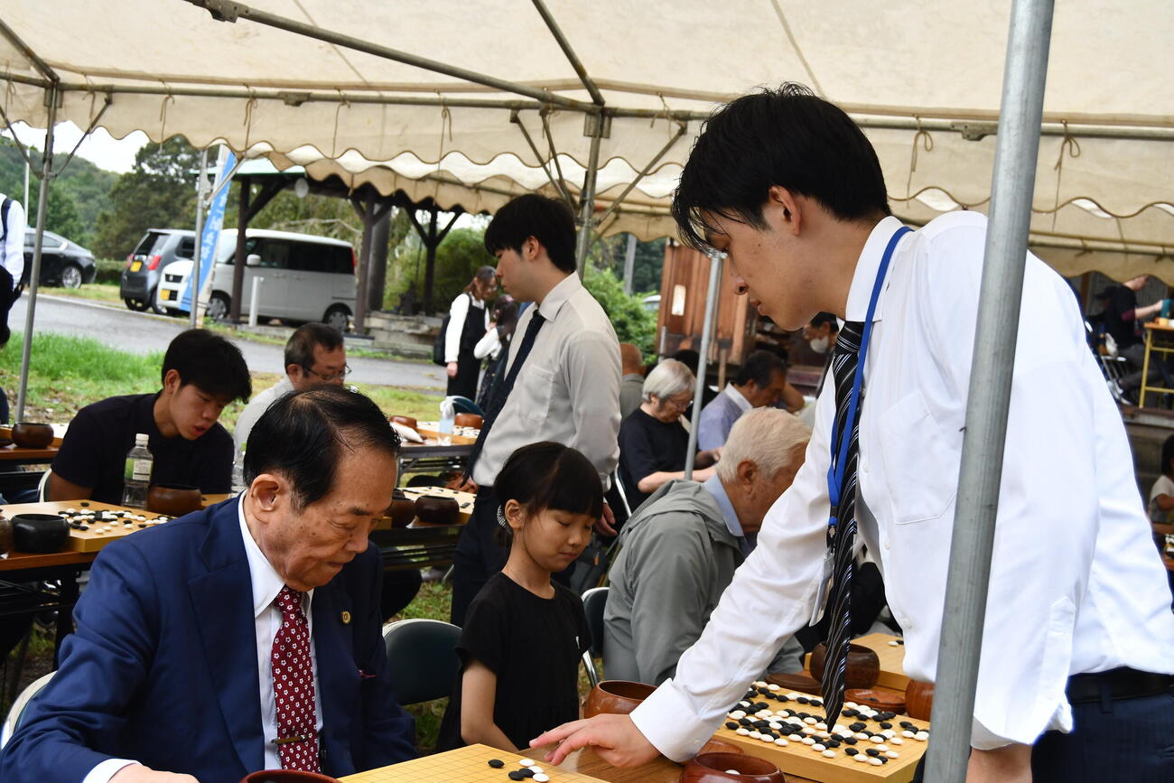 「新しき村」の千賀修一副理事長（左）は自ら河原裕二段（右）に指導碁を受ける