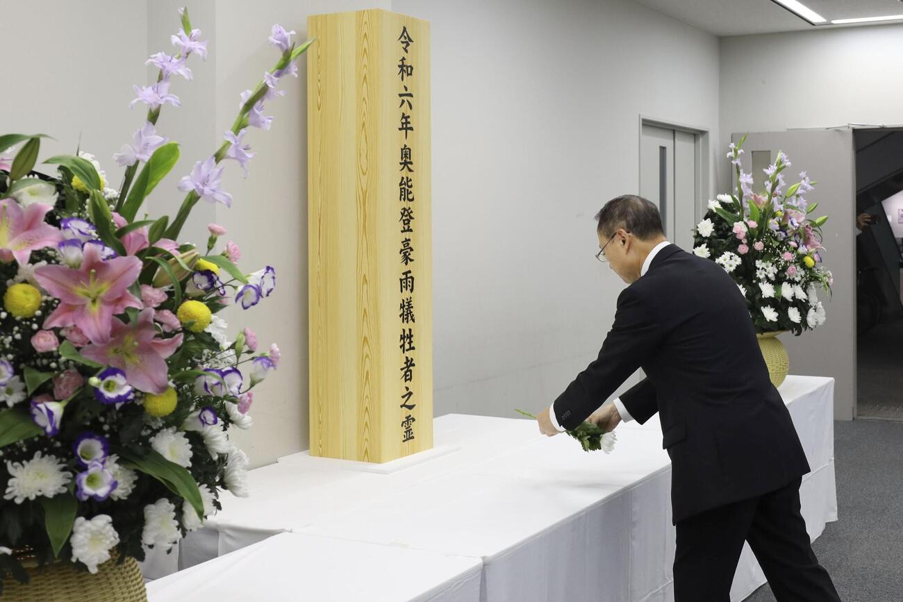 石川県庁に設置された献花台に花を手向ける山野之義知事＝21日午前(共同)