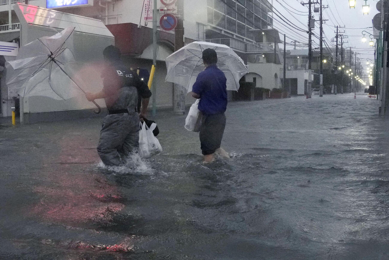 冠水した千葉県市川市の道路を歩く人たち。台風25号の影響で関東を中心に広い範囲で大雨が降った＝21日午後4時53分(共同)