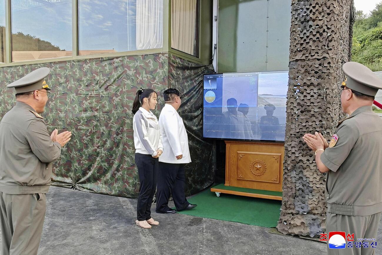 北朝鮮のミサイル総局が実施した新型兵器の試験をモニターで確認する金正恩朝鮮労働党総書記（中央右）と娘＝20日（朝鮮中央通信＝共同）