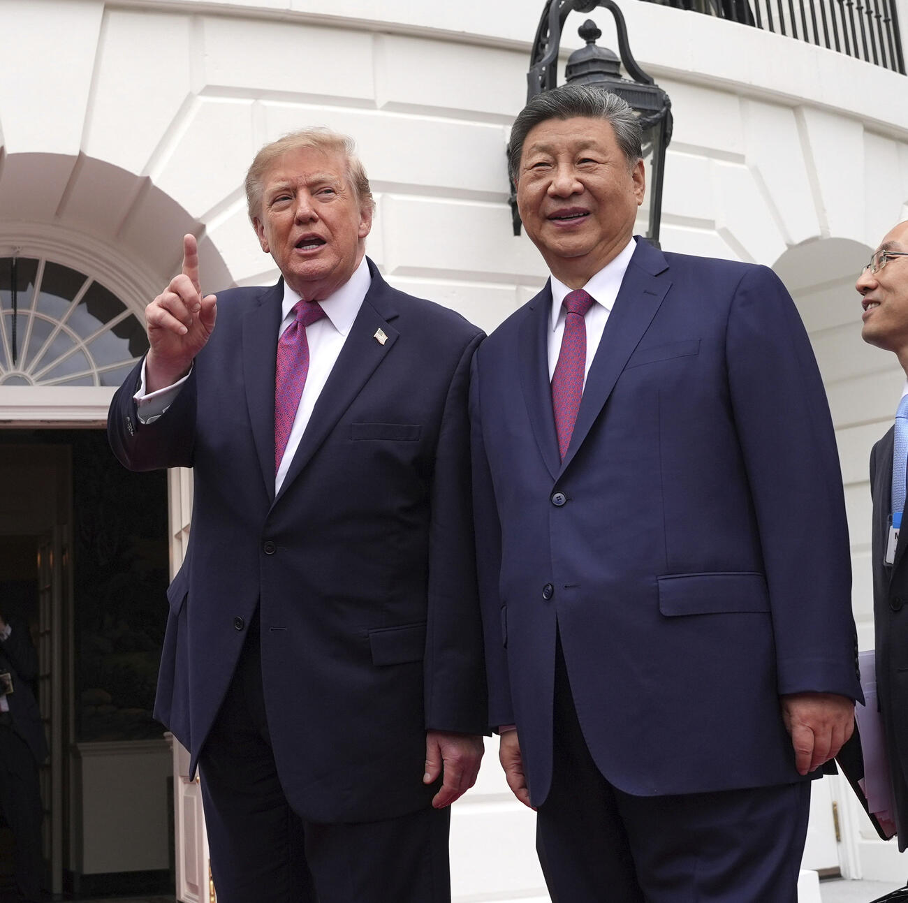 ホワイトハウスで記者団に話すトランプ米大統領。右は中国の習近平国家主席＝24日、ワシントン（AP＝共同）