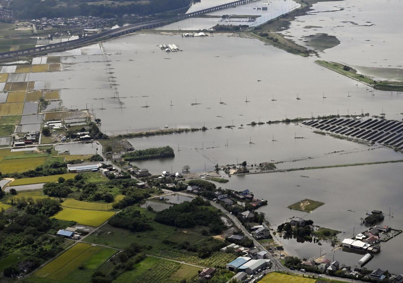 堤防（右上）が決壊した千葉県の印旛沼と冠水した周辺地域＝24日午前（共同）