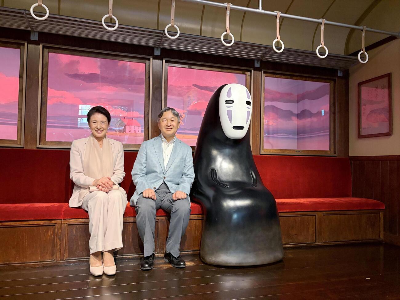 ジブリパークの展示で、映画「千と千尋の神隠し」の「カオナシ」の隣に腰かけられる天皇、皇后両陛下＝20日、愛知県長久手市（共同、宮内庁侍従職提供）