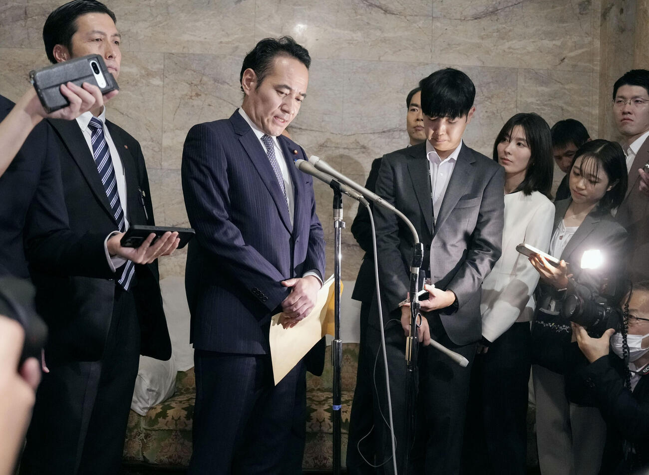 記者団の取材に応じる簗農相。自治体予算削減発言を撤回し、謝罪した（共同）