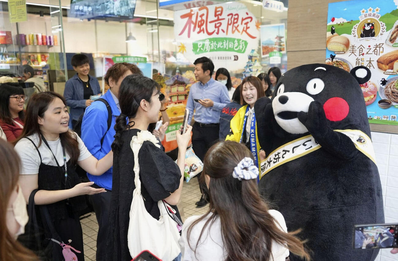台湾・台北市のファミリーマート前で市民に囲まれる熊本県のPRキャラクター「くまモン」＝6日（共同）