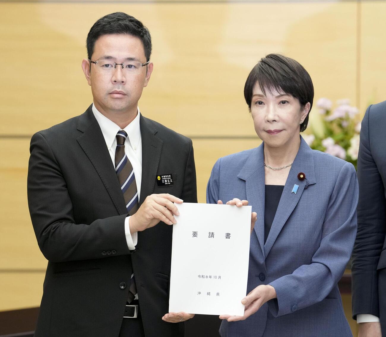 在沖縄米兵の事件を受け、高市首相（右）に要請書を手渡す沖縄県の古謝玄太知事（共同）