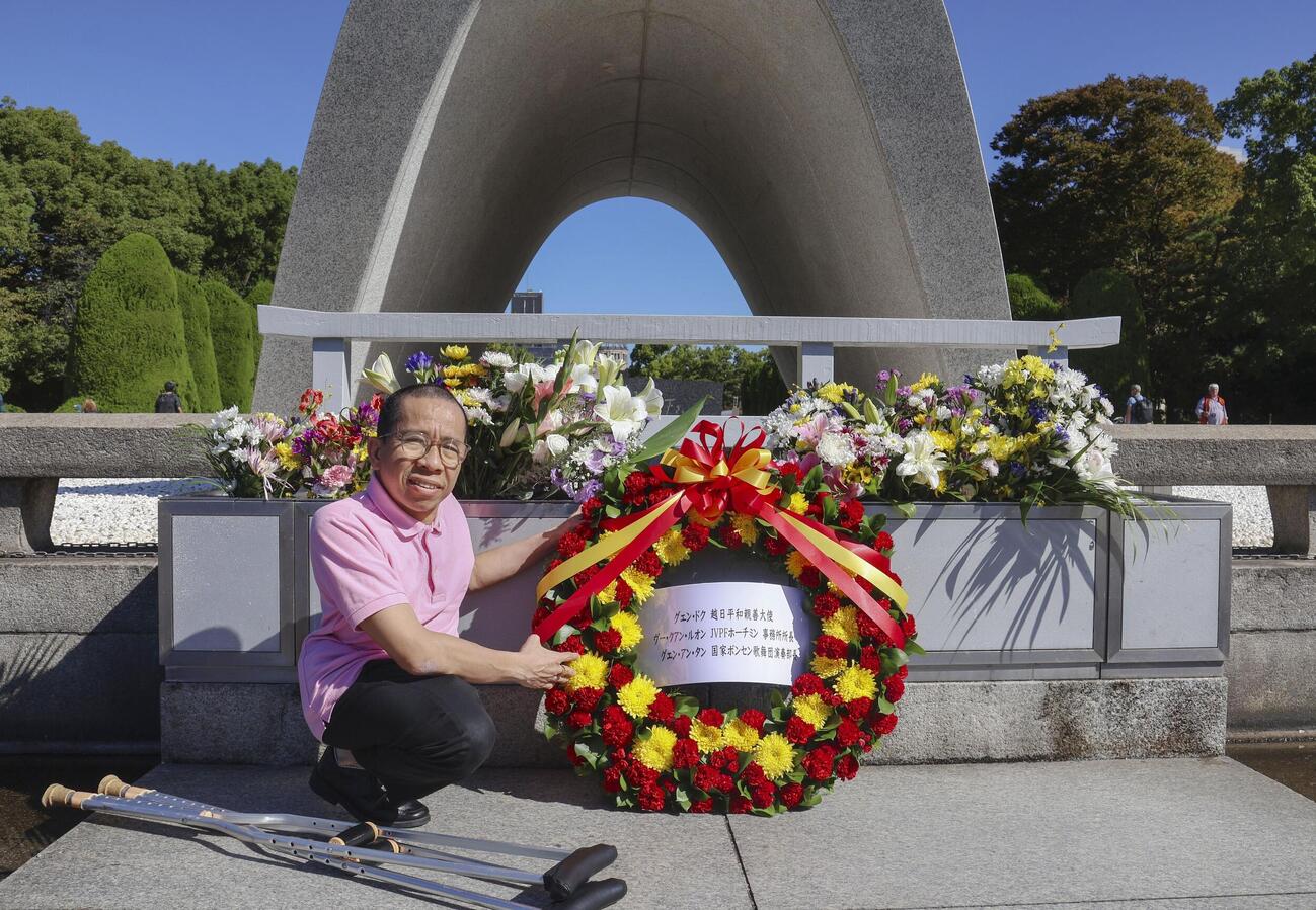 原爆慰霊碑に献花するグエン・ドクさん＝9日午前、広島市の平和記念公園(共同)