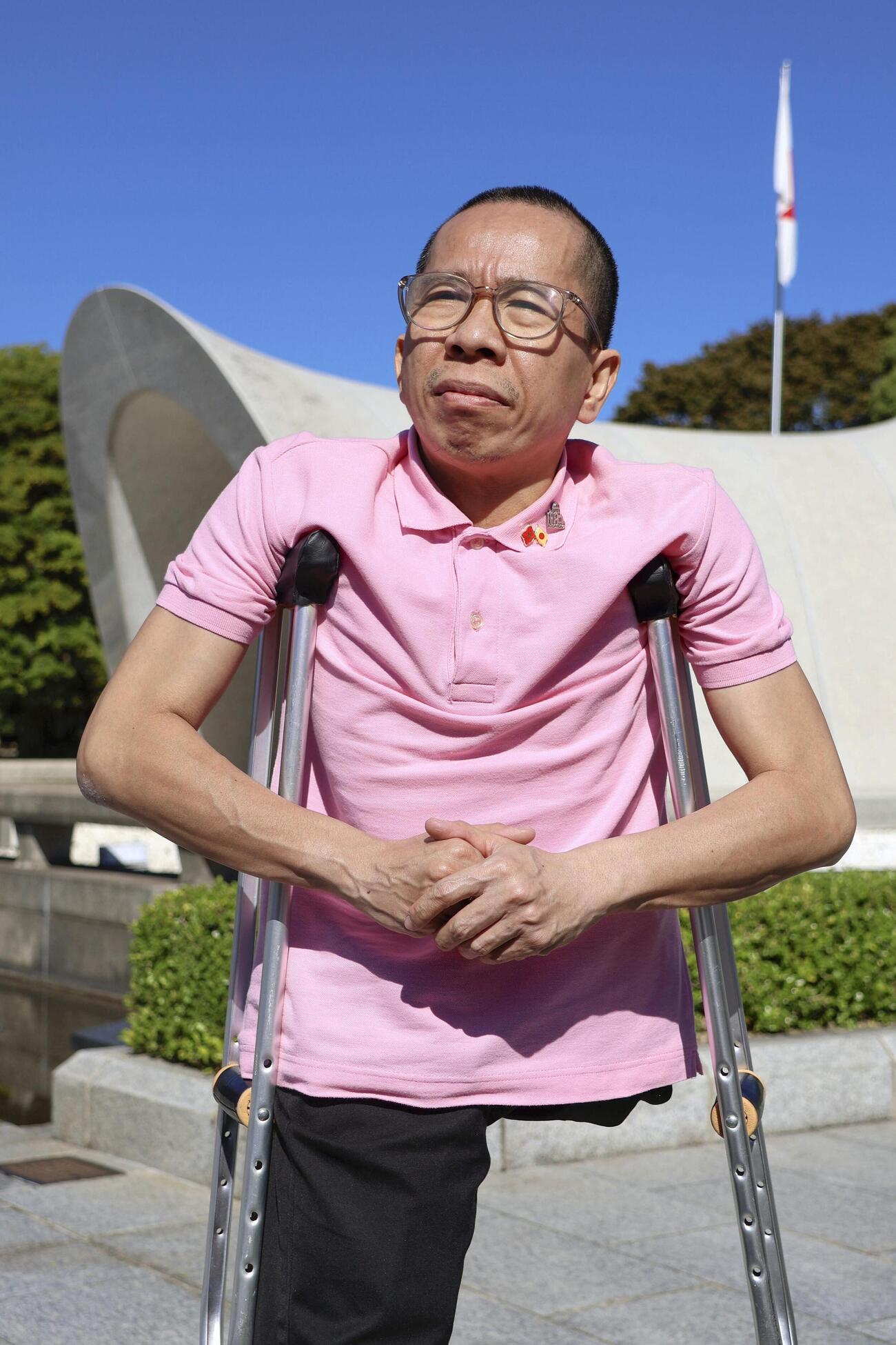 原爆慰霊碑に献花し、取材に応じるグエン・ドクさん＝9日午前、広島市の平和記念公園(共同)