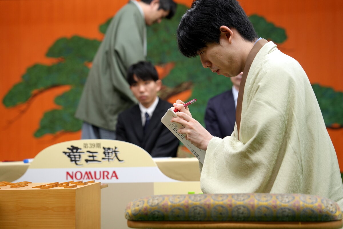 封じ手の入った封筒に署名する藤井聡太竜王（日本将棋連盟提供）