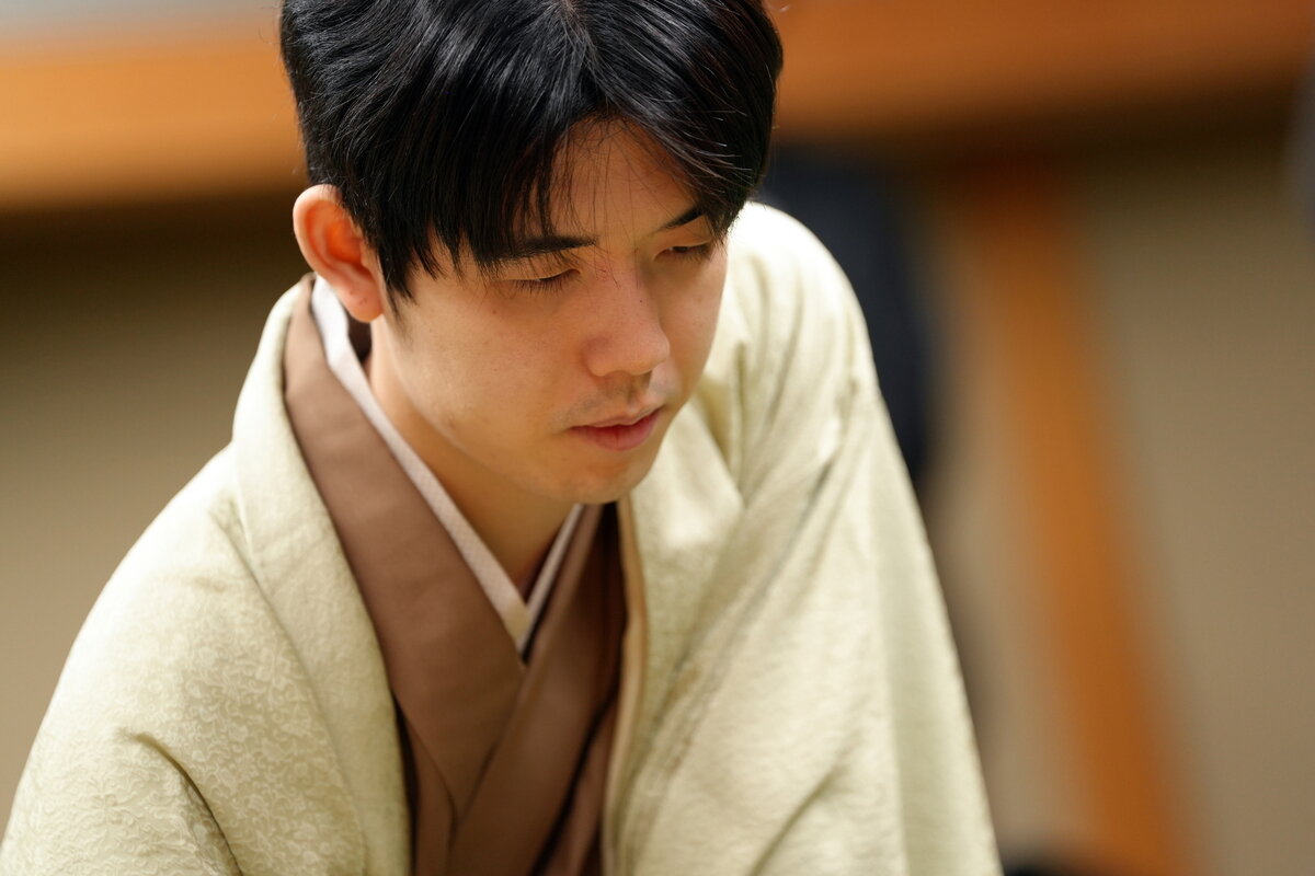 第1局の盤上に集中する藤井聡太竜王（日本将棋連盟提供）