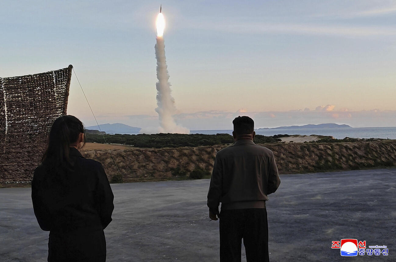 3日、北朝鮮東部で行われた中距離戦略ミサイルの発射訓練を視察する金正恩朝鮮労働党総書記（右）と娘（朝鮮通信＝共同）