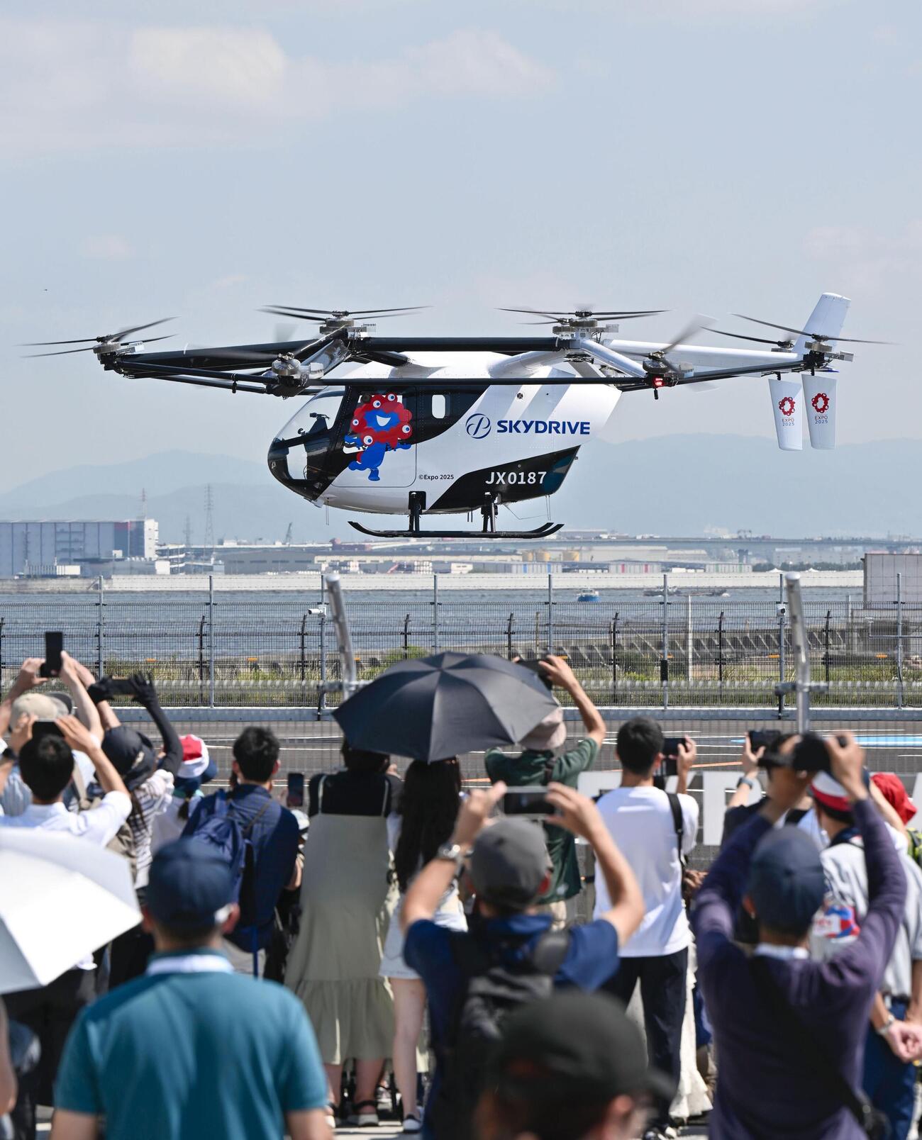 スカイドライブが開発した「空飛ぶクルマ」のデモ飛行＝2025年7月、大阪市此花区の夢洲(共同)