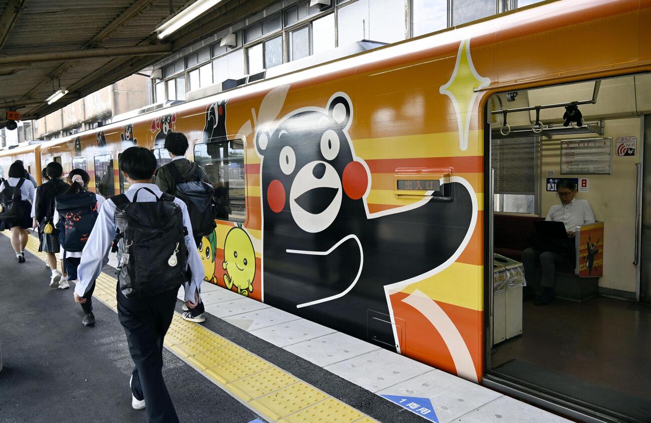 八代駅で「肥薩おれんじ鉄道」の列車に乗り込む人たち＝13日午前、熊本県八代市（共同）