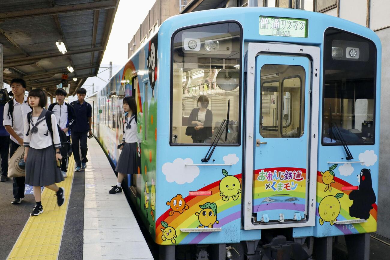 八代駅で「肥薩おれんじ鉄道」の列車から降りる人たち＝13日午前、熊本県八代市（共同）