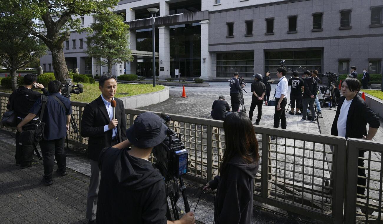餃子の王将社長射殺事件で、無期懲役求刑の被告に無罪判決が出たことを伝える報道陣(共同)