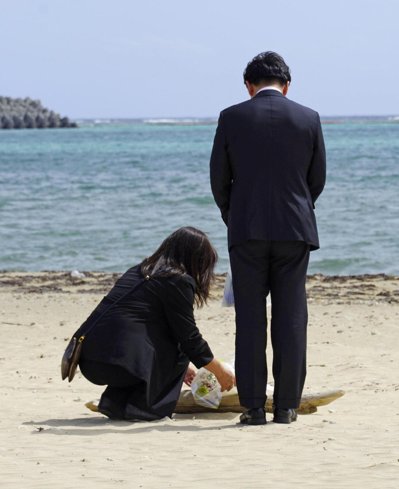 沖縄県名護市辺野古の浜に花を手向ける武石知華さんの両親(共同)
