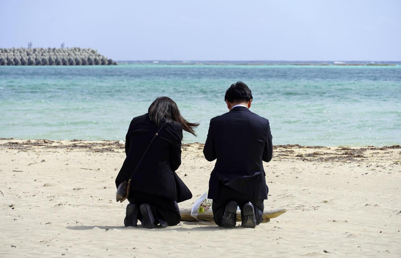 沖縄県名護市辺野古の浜に花を手向けた武石知華さんの両親(共同)