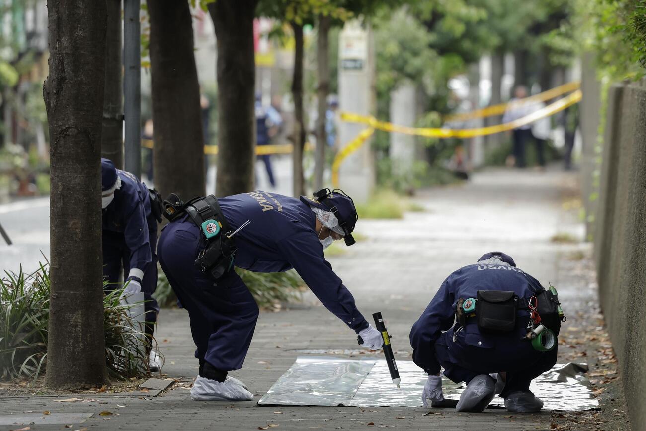 男性が刺された大阪地裁付近の現場を調べる大阪府警の捜査員（共同）