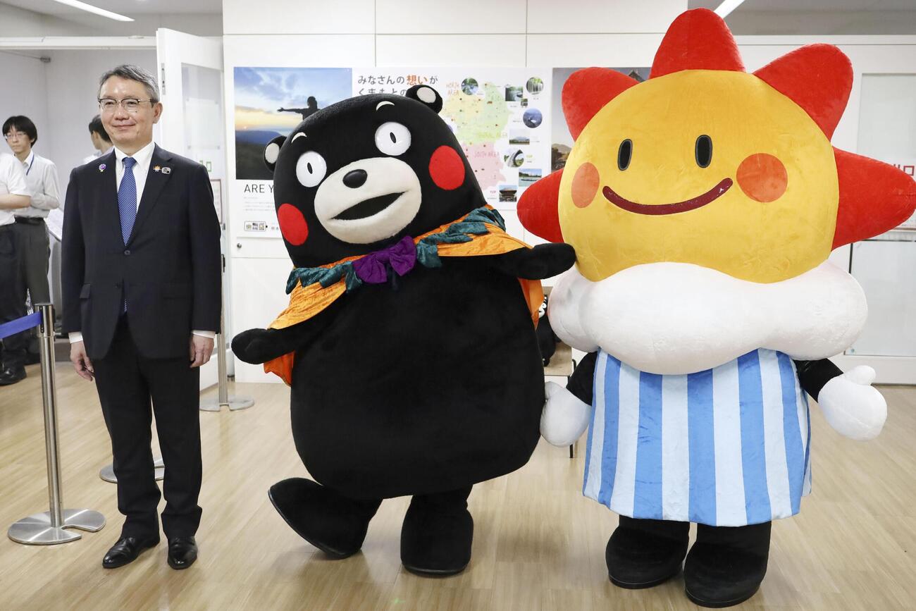 気象庁の野村竜一長官（左）、マスコットキャラクター「はれるん」（右）と写真に納まる「くまモン」（共同）