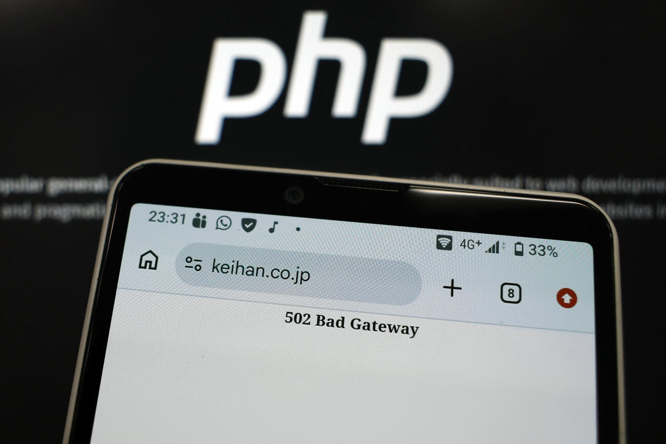 プログラミング言語「PHP」に欠陥が見つかった影響で、京阪ホールディングスが一時停止したホームページの画面（手前）＝21日夜（共同）