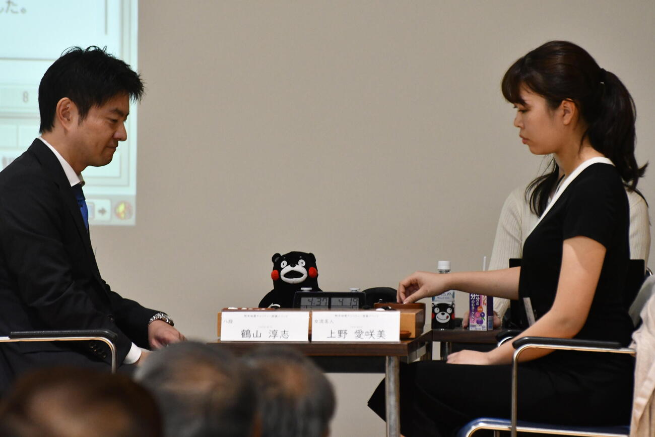 くまモンが見守る前で公開対局を行った鶴山淳志八段（左）と上野愛咲美女流名人（右）