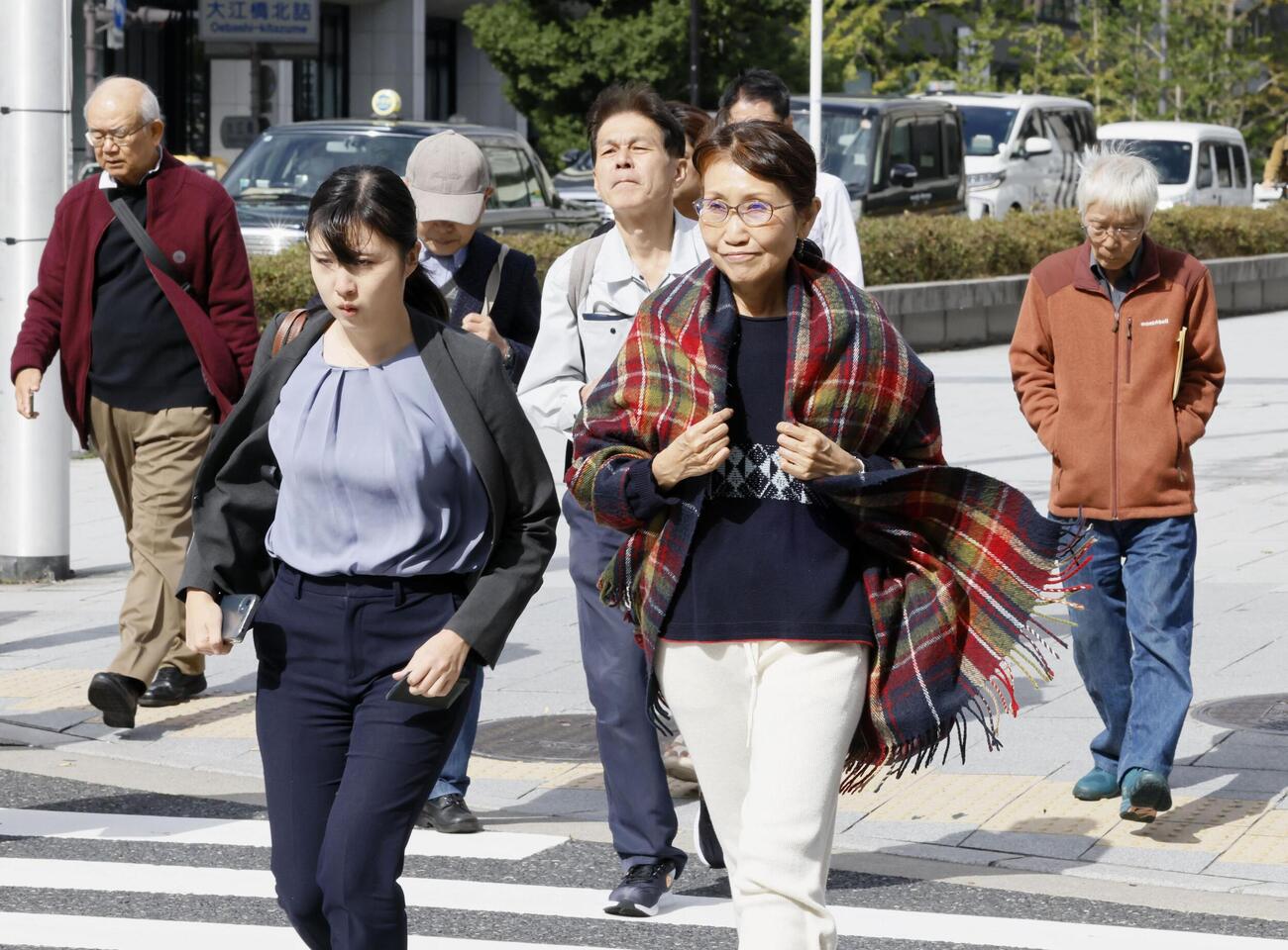 大阪市内を歩く人たち。気象庁は「木枯らし1号」が吹いたと発表した＝28日午後（共同）