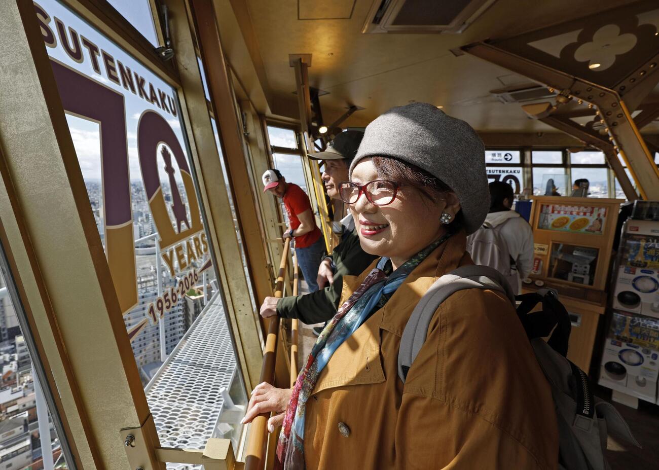 「70YEARS」の文字などで飾られた「通天閣」の展望台を訪れた観光客＝28日午前、大阪市浪速区