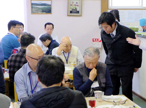 12日、国後島の宿舎で、前夜酒に酔い騒いだことについて謝罪する丸山穂高衆院議員（右端）（同行記者団撮影）