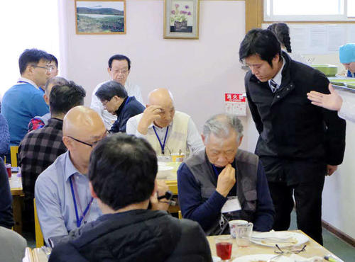 12日、国後島の宿舎で、酒に酔い騒いだことについて謝罪する丸山穂高衆院議員（右端）（同行記者団撮影）