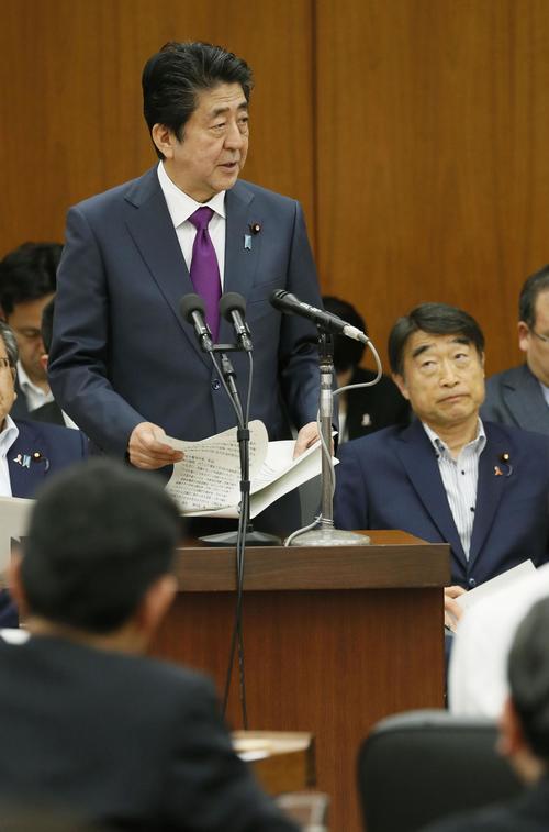 衆院厚労委で答弁する安倍首相。右は根本厚労相（共同）