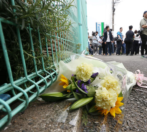 無差別事件が起きたファミリーマート登戸新町店前の路肩に添えられる献花（撮影・河田真司）