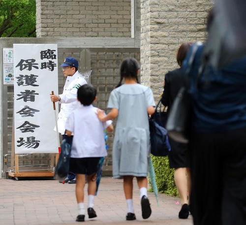 臨時保護者会が開かれるカリタス小の校舎に向かう保護者たち（撮影・垰建太）