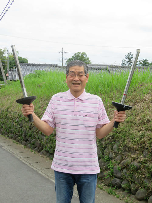 練習で使ったトーチを右手に、本番用のトーチを左手に持つ落合さん。「わが家の唯一の宝です」と笑った