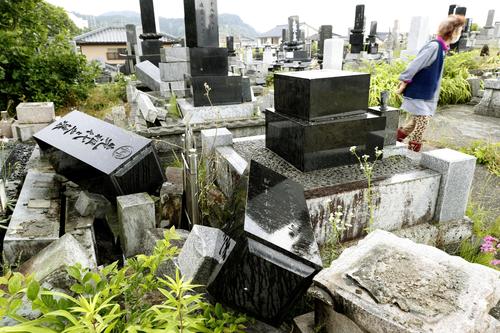 地震で墓石が倒れた墓地＝19日午前6時18分、新潟県村上市（共同）
