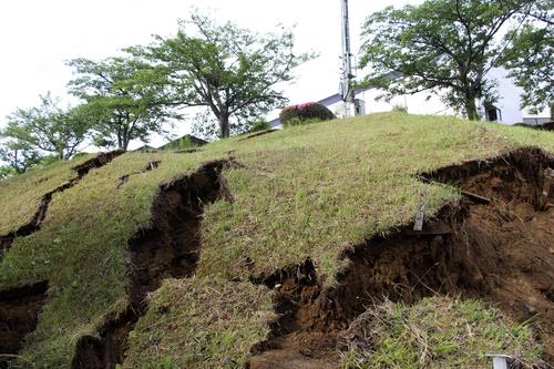 強い地震で崩れた新潟県村上市の山北総合体育館敷地内の斜面＝19日午前6時45分（共同）