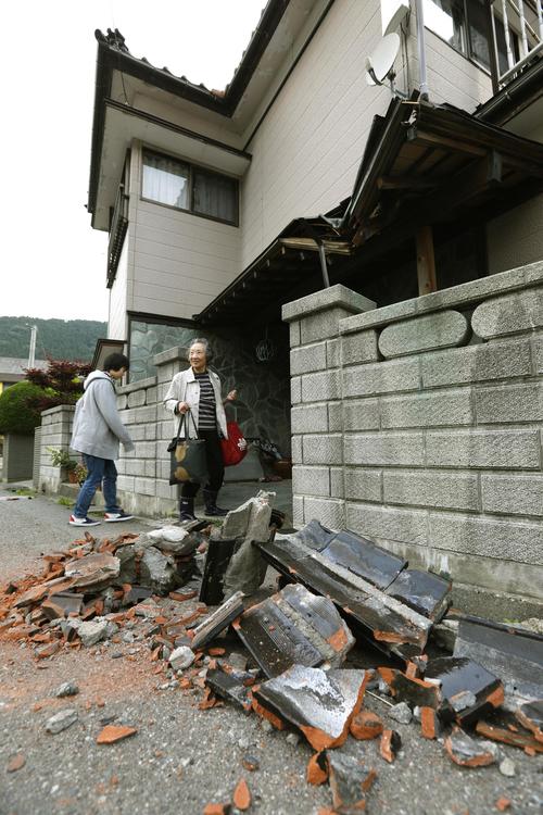住宅の玄関前に積まれた屋根から落ちた瓦＝19日午前5時22分、山形県鶴岡市（共同）