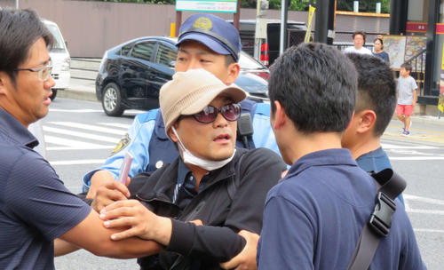 大阪市内で連行される際、必死に抵抗する宮崎文夫容疑者（中央）（撮影・佐藤勝亮）