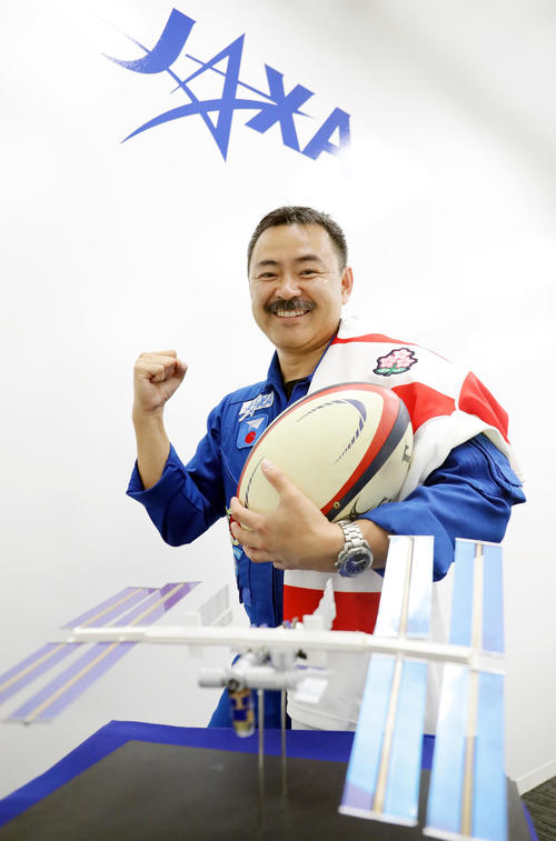 ラグビー日本代表のユニホームを肩にかけてボールを手にガッツポーズの星出彰彦氏（撮影・浅見桂子）
