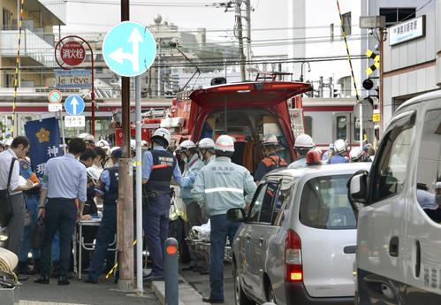 京浜急行の車両がトラックと衝突し、脱線した現場に集まった救急隊員ら（共同）