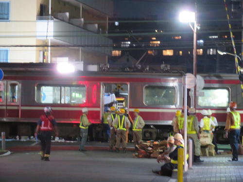 京浜急行の神奈川新町－仲木戸間の踏切で、トラックと衝突し脱線した車両のドアを開けて調査する職員（撮影・村上幸将）
