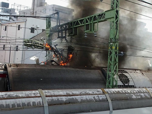 京浜急行の電車とトラックが衝突し、黒煙が上がる事故現場＝5日、横浜市神奈川区（住民提供、共同）