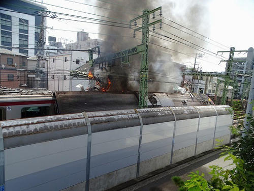 京浜急行の電車とトラックが衝突し、黒煙が上がる事故現場（住民提供、共同）