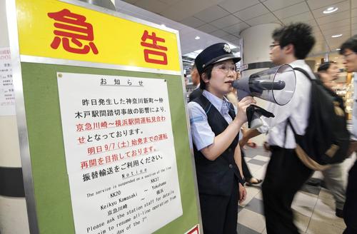 京急川崎駅の改札前で、運転の見合わせを伝える掲示板と駅員（共同）
