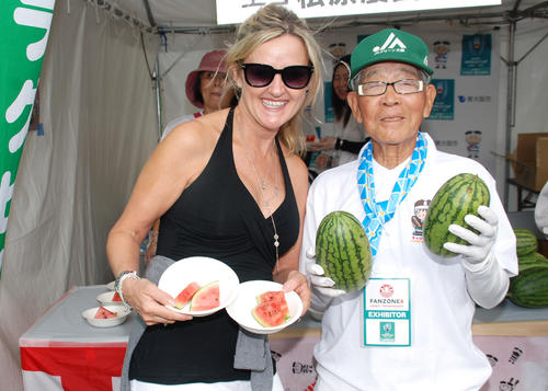 米国から来た女性に「ラグビースイカ」をふるまった松原功典さん（右）（撮影・松浦隆司）